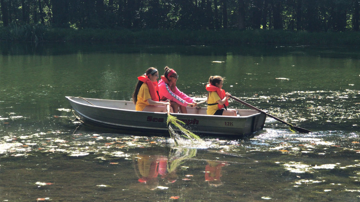 Campers in a row boat on the lake