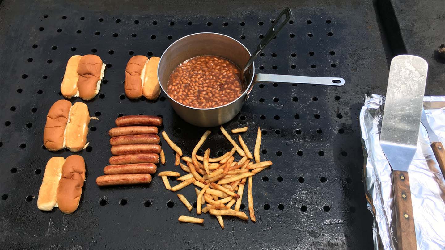 Hot dogs, fries, and beans on the grill