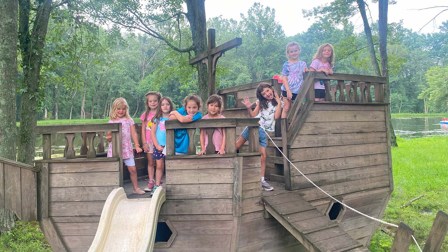 Campers playing on our wooden pirate ship in the playground